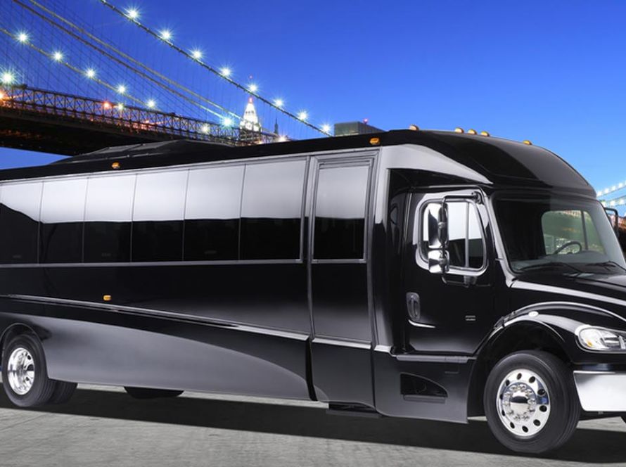 Limo bus parked at night under lights