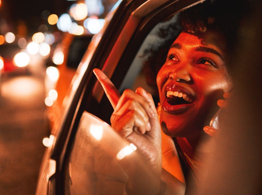 Happy woman looking out of the limo window.
